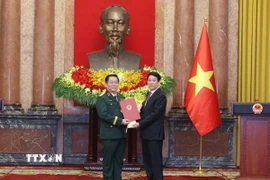 Chủ tịch nước Lương Cường trao Quyết định bổ nhiệm đồng chí Nguyễn Trọng Nghĩa giữ chức Chủ nhiệm Tổng cục Chính trị Quân đội nhân dân Việt Nam, đồng thời thăng quân hàm từ Thượng tướng lên Đại tướng. (Ảnh: Lâm Khánh/TTXVN)