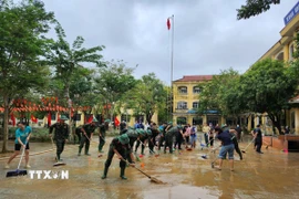 Các chiến sỹ Trung đoàn 6, Bộ Chỉ huy Quân sự thành phố Huế hỗ trợ nhân dân dọn dẹp vệ sinh sau mưa lũ. (Ảnh: Mai Trang/TTXVN)