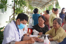 Bác sỹ Trạm Y tế Long Sơn khám bệnh cho người dân tại Chương trình chăm sóc sức khỏe cộng đồng. (Ảnh: Hoàng Nhị/TTXVN)
