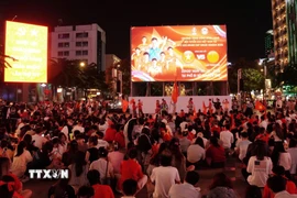 Người hâm mộ ngồi trật tự chuẩn bị xem trận bán kết qua màn hình Led khổng lồ có kích thước 12m x 7m tại phố đi bộ Nguyễn Huệ. (Ảnh: Trung Tuyến/TTXVN)