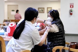 Nhân viên y tế tiêm vaccine phòng COVID-19 cho người dân. (Ảnh: THX/TTXVN)