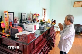 Thân nhân nhà báo, liệt sỹ Nguyễn Hữu Bản (sinh năm 1921 tại thôn Đại Lai, xã Phú Xuân, thị xã Thái Bình nay là phường Trần Hưng Đạo, tỉnh Hưng Yên) dâng hương trước ban thờ ông. (Ảnh: Thế Duyệt/TTXVN)