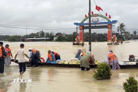 Sử dụng ghe để tiếp tế lương thực cho người dân vùng lũ. (Ảnh: Tường Quân/TTXVN)