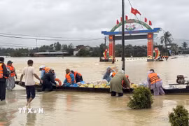 Sử dụng ghe để tiếp tế lương thực cho người dân vùng lũ. (Ảnh: Tường Quân/TTXVN)