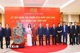 Chủ tịch Quốc hội Trần Thanh Mẫn và đại biểu với nghệ nhân tại Lễ tiếp nhận tác phẩm điêu khắc ánh sáng. (Ảnh: Doãn Tấn/TTXVN)