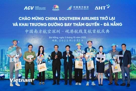 Những du khách đầu tiên từ Thâm Quyến (Trung Quốc) đến Đà Nẵng được chào đón và tặng quà lưu niệm. (Ảnh: PV/Vietnam+)