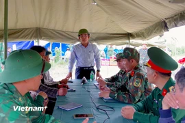 Phó Chủ tịch Ủy ban nhân dân thành phố Đà Nẵng Trần Nam Hưng (đứng giữa) chỉ đạo các lực lượng tại Sở Chỉ huy tiền phương. (Ảnh: PV/Vietnam+)