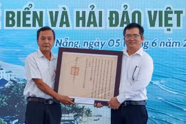 Ông Mai Văn Khôi đại diện Tộc Mai Văn hiến tặng 07 sắc bằng liên quan đến thủy quân triều Nguyễn cho Nhà Trưng bày Hoàng Sa. (Ảnh: Thanh Phong/Vietnam+)