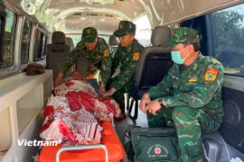 Cán bộ, chiến sĩ Đồn biên phòng Ga Ry kịp thời đưa sản phụ người Lào đi cấp cứu. (Ảnh: PV/Vietnam+)