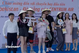 Ngành du lịch thành phố Đà Nẵng chụp hình lưu niệm với nhóm du khách đầu tiên trên chuyến bay từ Tashkent, Uzbekistan đến Đà Nẵng. (Ảnh: Thanh Phong/Vietnam+)