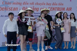 Ngành du lịch thành phố Đà Nẵng chụp hình lưu niệm với nhóm du khách đầu tiên trên chuyến bay từ Tashkent, Uzbekistan đến Đà Nẵng. (Ảnh: Thanh Phong/Vietnam+)