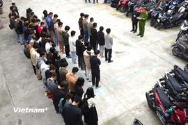 Công an đọc lệnh khởi tố một số đối tượng trong đường dây "núp bóng" công ty công nghệ để vi phạm pháp luật. (Ảnh: Công an Đà Nẵng)