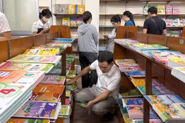 Phụ huynh chật vật tìm mua sách giáo khoa cho con. (Ảnh: Phạm Mai/Vietnam+)