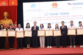 Thứ trưởng Bộ Giáo dục và Đào tạo Lê Quân và Bí thư Trung ương Đoàn Nguyễn Tường Lâm tặng bằng khen cho các giáo viên. (Ảnh: PV/Vietnam+)