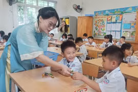 Giáo viên chào đón học sinh trong ngày đầu vào lớp 1. (Ảnh: Phạm Mai/Vietnam+)