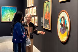 Nghệ sỹ Tô Bích Hải giới thiệu tranh với khách tham quan. (Ảnh: Minh Ngọc/Vietnam+).