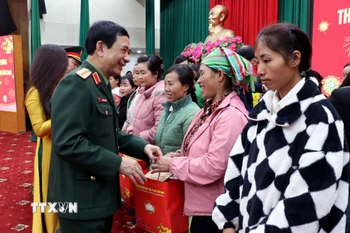 Đại tướng Phan Văn Giang trao quà Tết cho các hộ nghèo. (Ảnh: Thu Hằng/TTXVN)