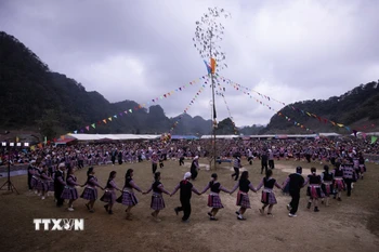 Phần hội diễn ra sôi nổi, rộn ràng với hình ảnh các chàng trai, cô gái, người già, trẻ nhỏ người Mông nắm tay nhau múa vòng quanh cây nêu trong tiếng khèn Mông. (Ảnh: Trọng Đạt/TTXVN)
