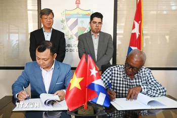 Ông Nguyễn Khắc Hoàng, Giám đốc công ty Hoàng Gia Việt, và đại diện của công ty nông nghiệp Alquizar, thuộc Tập đoàn doanh nghiệp Nông Lâm nghiệp Artemisa của Cuba, ký hợp đồng hợp tác. (Ảnh: Việt Hùng/TTXVN)