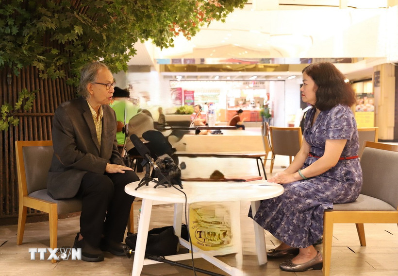 Học giả Thái Lan Kavi Chongkittavorn (trái) trong cuộc trao đổi với phóng viên TTXVN. (Ảnh: Huy Tiến/TTXVN)