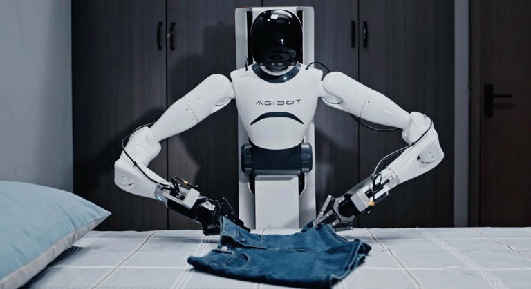 Một người đàn ông điều khiển robot Agibot. (Nguồn: AFP)