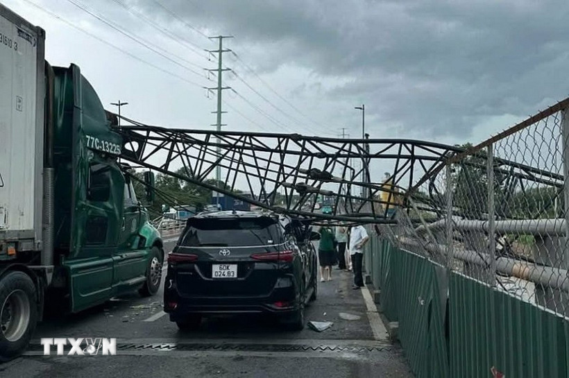 Cần cẩu thi công đè trúng hai xe ôtô trên cầu vượt Mỹ Thủy, thành phố Thủ Đức. (Ảnh: TTXVN phát)