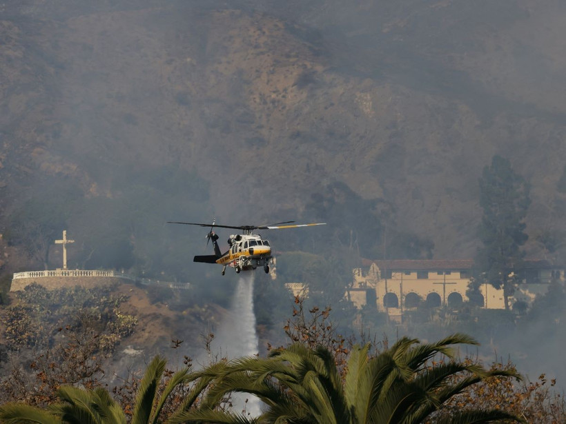 Trực thăng phun nước dập lửa cháy rừng tại Malibu, California, Mỹ. (Ảnh: THX/TTXVN)
