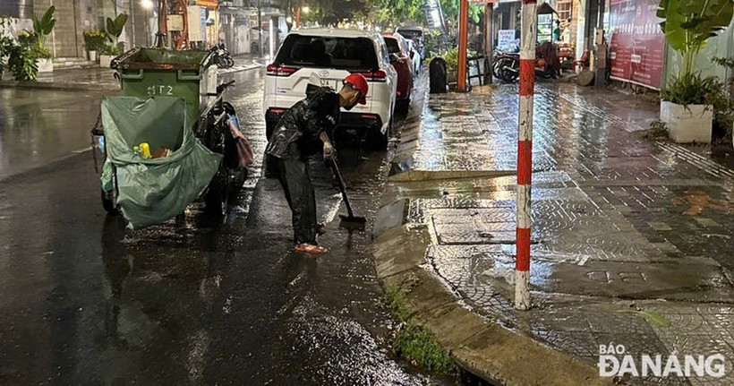 Công nhân dọn vệ sinh trên đường phố và khơi thông thoát nước sau khi nước rút vào rạng sáng 12/6. (Nguồn: Báo Đà Nẵng)