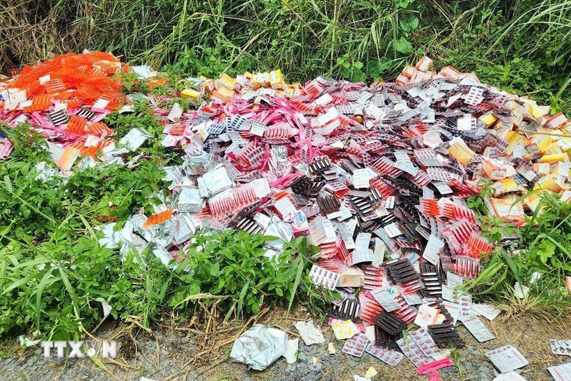 Các đối tượng lợi dụng đêm tối, đi xe ba gác chở sản phẩm đến đổ bỏ và rời đi nhanh chóng. (Ảnh: Hương Giang/TTXVN)