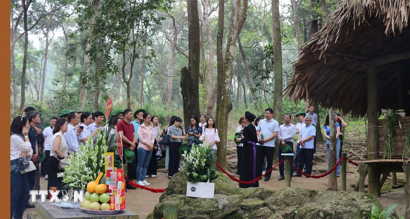 Du khách dâng hương và nghe thuyết minh tại lán Nà Nưa, Khu di tích Quốc gia đặc biệt Tân Trào, xã Tân Trào (Tuyên Quang). (Ảnh: Hoàng Hải/TTXVN)