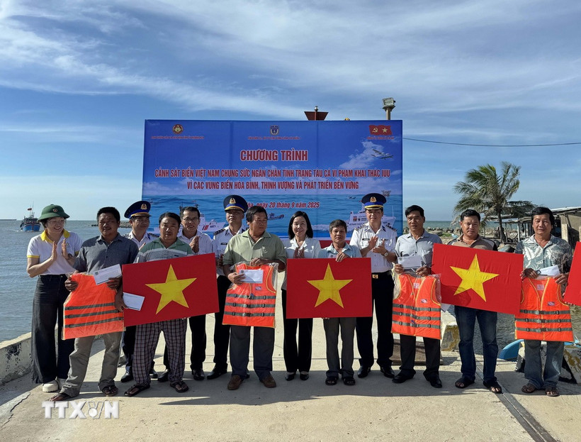 Hải đoàn 32 - Bộ Tư lệnh Vùng Cảnh sát biển 3 tặng quà và cờ Tổ quốc cho ngư dân xã Cà Ná. (Ảnh: TTXVN phát)