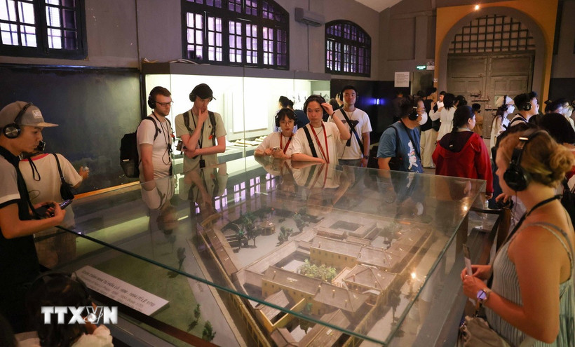 Du khách sử dụng bộ đàm thuyết minh tự động khi tham quan di tích Nhà tù Hỏa Lò, Hà Nội. (Ảnh: Thanh Tùng/TTXVN)