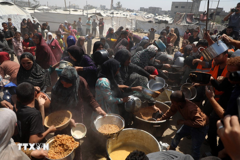 Người dân Palestine nhận thực phẩm cứu trợ tại Gaza. (Ảnh: THX/TTXVN)