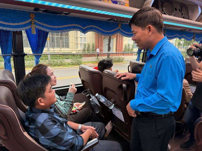 Ông Phạm Chí Tâm, Phó Chủ tịch Liên đoàn Lao động Thành phố Hồ Chí Minh, thăm hỏi, động viên người lao động trên chuyến xe về quê đón Tết. (Ảnh: Thanh Vũ/TTXVN)