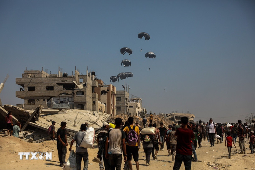 Hàng viện trợ được thả từ máy bay xuống Dải Gaza. (Ảnh: THX/TTXVN)