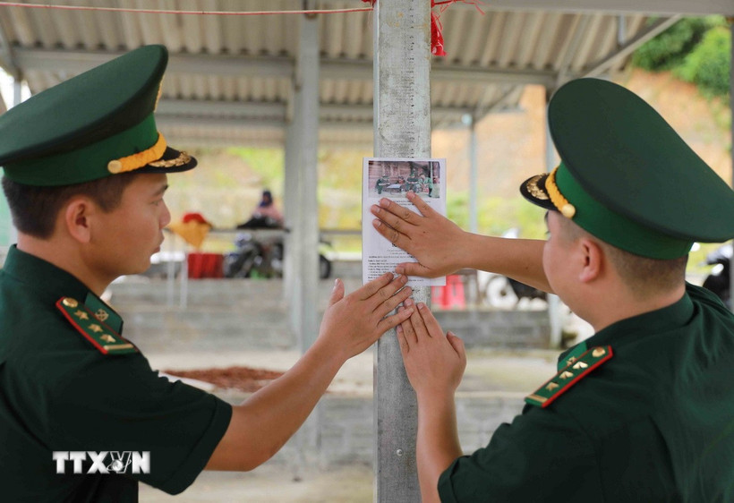 Dán mã QR tại chợ của xã Sin Suối Hồ để người dân dễ tiếp cận nhằm tố giác tội phạm tới hòm thư của đơn vị. (Ảnh: Quý Trung/TTXVN)