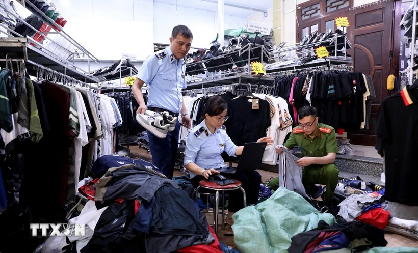 Lực lượng quản lý thị trường tỉnh Tuyên Quang kiểm tra, lập biên bản một cửa hàng kinh doanh quần áo có dấu hiệu giả mạo nhãn hiệu tại phường Minh Xuân, thành phố Tuyên Quang. (Ảnh: Quang Cường/TTXVN)