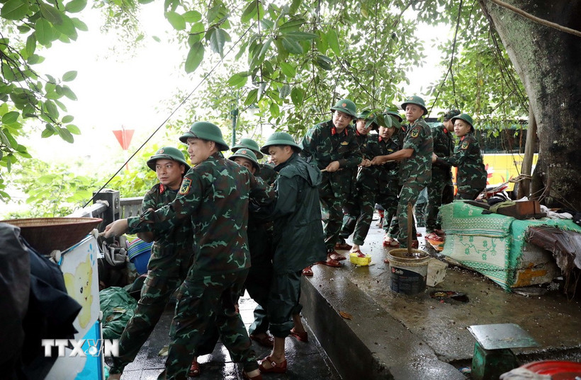 Các chiến sỹ Bộ Chỉ huy Quân sự tỉnh Tuyên Quang hỗ trợ người dân nhà bè trên sông Lô gia cố nơi ở. (Ảnh: Quang Cường/TTXVN)