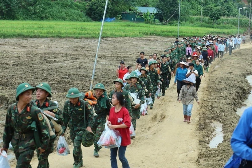 Người dân thôn Làng Nủ (xã Phúc Khánh, huyện Bảo Yên, tỉnh Lào Cai) bịn rịn chia tay các chiến sỹ thuộc Trung đoàn 98, Sư đoàn 316 của Quân khu 2 rút quân khỏi thôn sau 14 ngày tham gia tìm kiếm các nạn nhân mất tích (24/9/2024). (Ảnh: TTXVN phát)