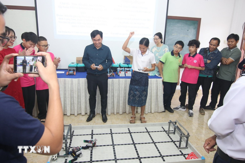 Các thầy cô giáo và các em học sinh đang trải nghiệm Robotics. (Ảnh: TTXVN phát)