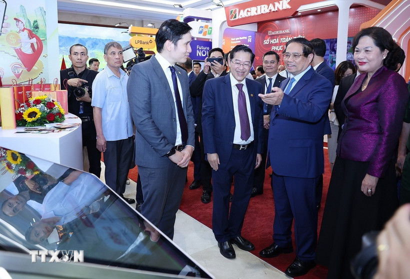 Thủ tướng Phạm Minh Chính tham quan trưng bày sản phẩm dịch vụ, ứng dụng chuyển đổi số trong hoạt động ngân hàng. (Ảnh: Dương Giang/TTXVN)