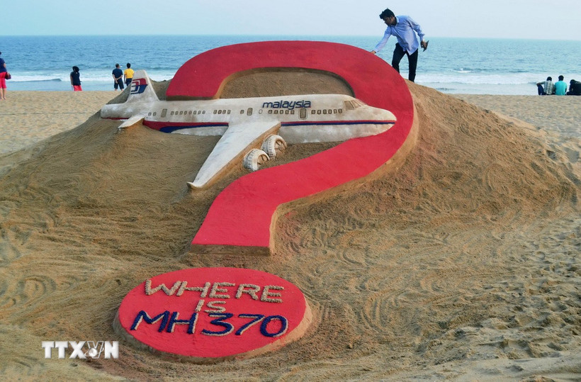 Nhà điêu khắc người Ấn Độ Sudarsan Pattnaik thể hiện tác phẩm điêu khắc trên cát "MH370 đang ở đâu?" trên bãi biển Puri ở bang Odisha, Ấn Độ, nhân kỷ niệm tròn một năm máy bay MH370 bị mất tích. (Ảnh: AFP/TTXVN)