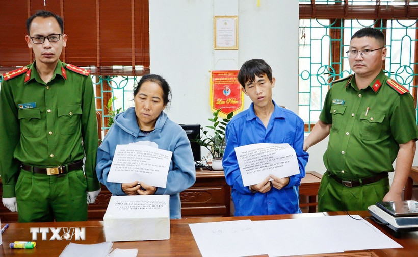 Hai đối tượng Giàng Thị Lâu và Sùng A Súa cùng tang vật phạm tội là 8 bánh heroin. (Ảnh: TTXVN phát)