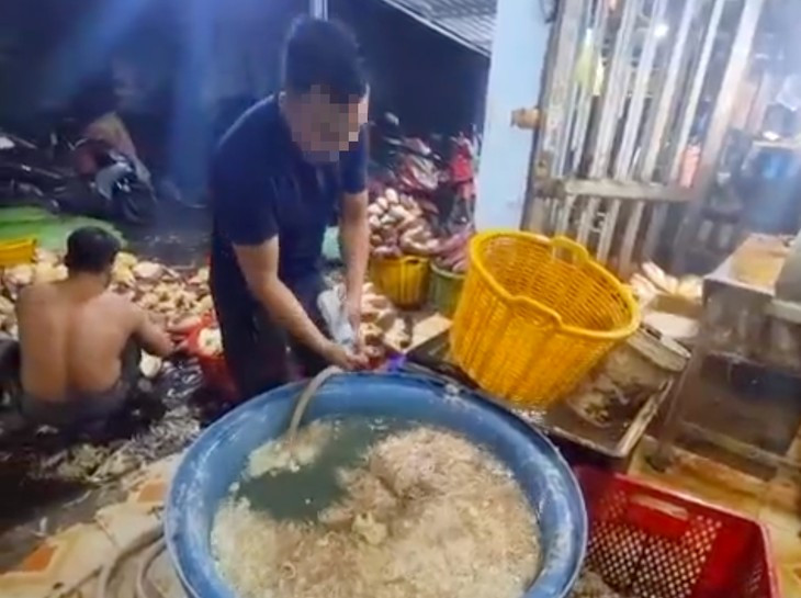 Nhân viên cơ sở sơ chế hoa chuối thực hành lại quá trình pha hóa chất vào nước ngâm hoa chuối. (Ảnh: Công an cung cấp)