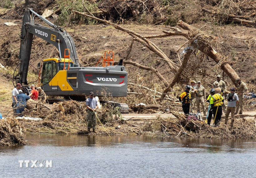 Lực lượng cứu hộ vẫn đang chạy đua với thời gian để tìm kiếm các nạn nhân bị nước lũ cuốn trôi. (Ảnh: THX/TTXVN)