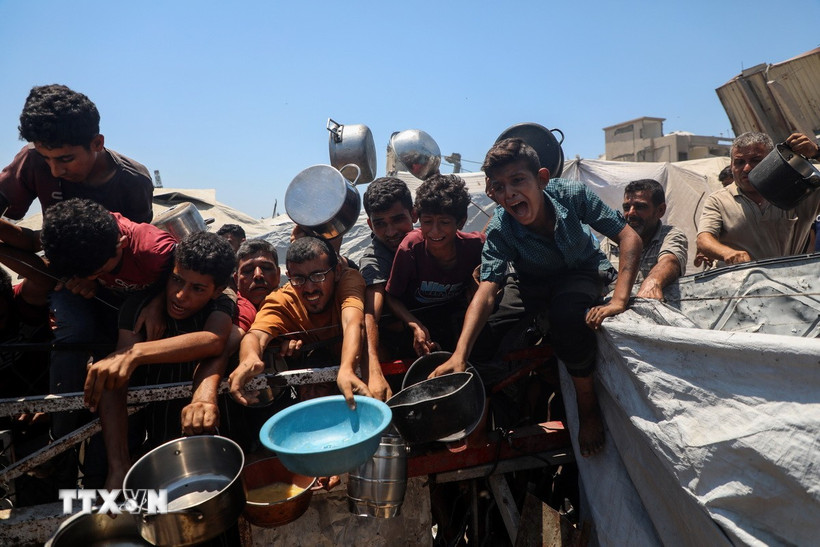 Người dân Palestine chờ nhận thức ăn cứu trợ tại thành phố Gaza. (Ảnh: THX/TTXVN)