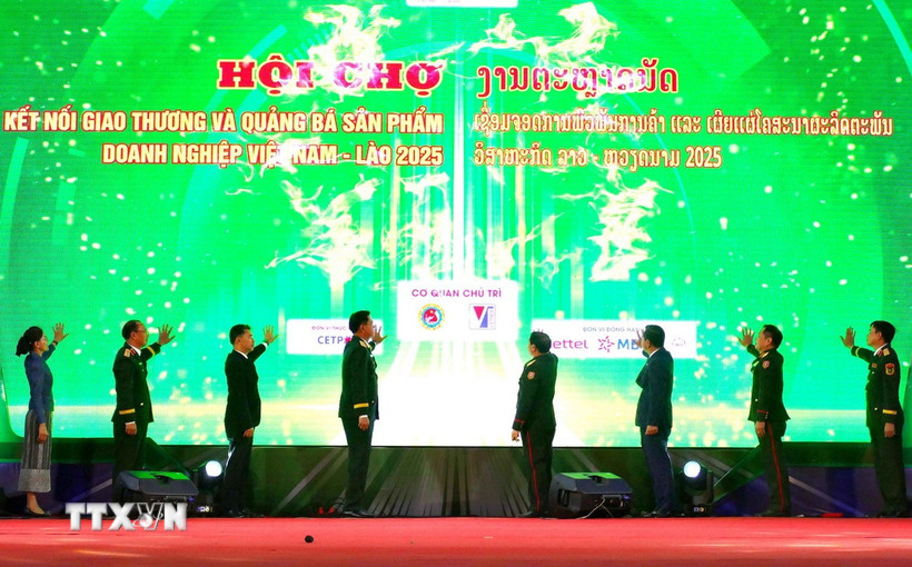 Các đại biểu hai nước Việt Nam-Lào nhấn nút khai mạc Hội chợ. (Ảnh: Xuân Tú/TTXVN)