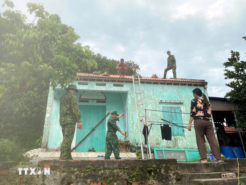Chiến sỹ Bộ đội Biên phòng đồn Ngọc Vừng (Bộ đội Biên phòng Quảng Ninh) giúp người dân chằng chống nhà cửa trước bão. (Ảnh: Thanh Vân/TTXVN)