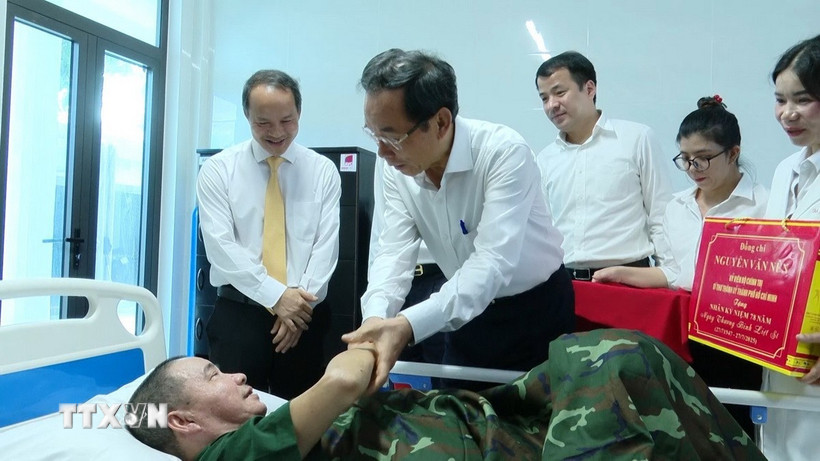 Ông Nguyễn Văn Nên động viên các thương, bệnh binh bệnh nặng đang nằm điều dưỡng tại phòng cấp cứu tại Trung tâm Điều dưỡng thương binh và người có công Long Đất. (Ảnh: Huỳnh Sơn/TTXVN)