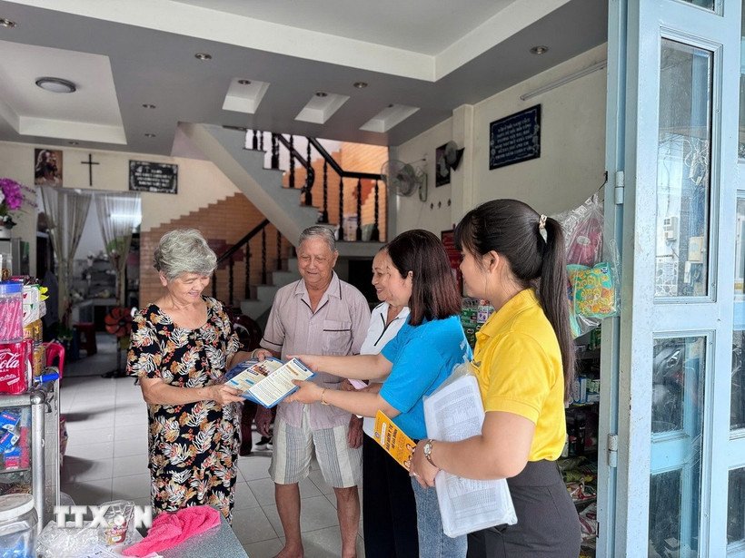 Cán bộ, nhân viên Bảo hiểm xã hội thành phố Cần Thơ tuyên truyền, vận động người dân tham gia bảo hiểm xã hội. (Ảnh: TTXVN phát)